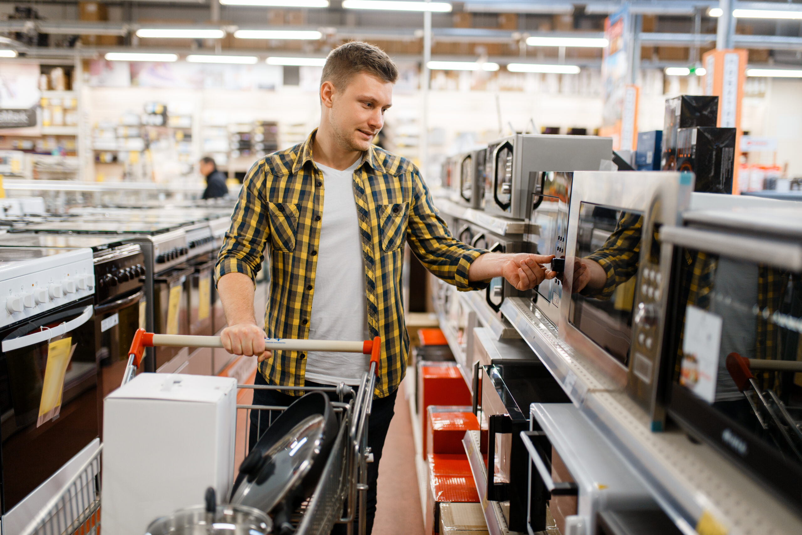 Man choosing microwave in electronics store