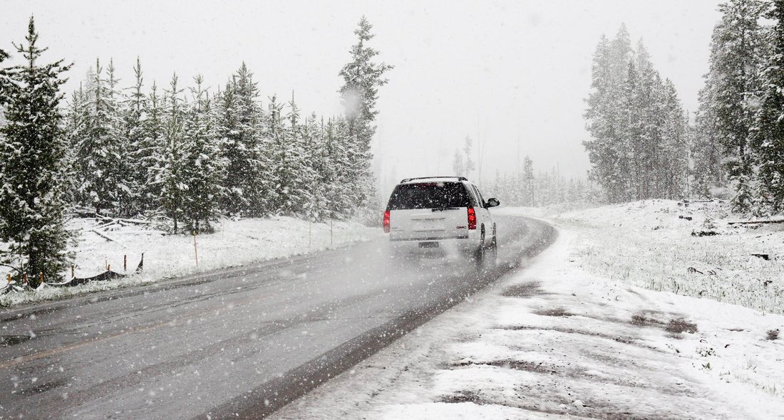Voiture roulant en montagne sur une route enneigée