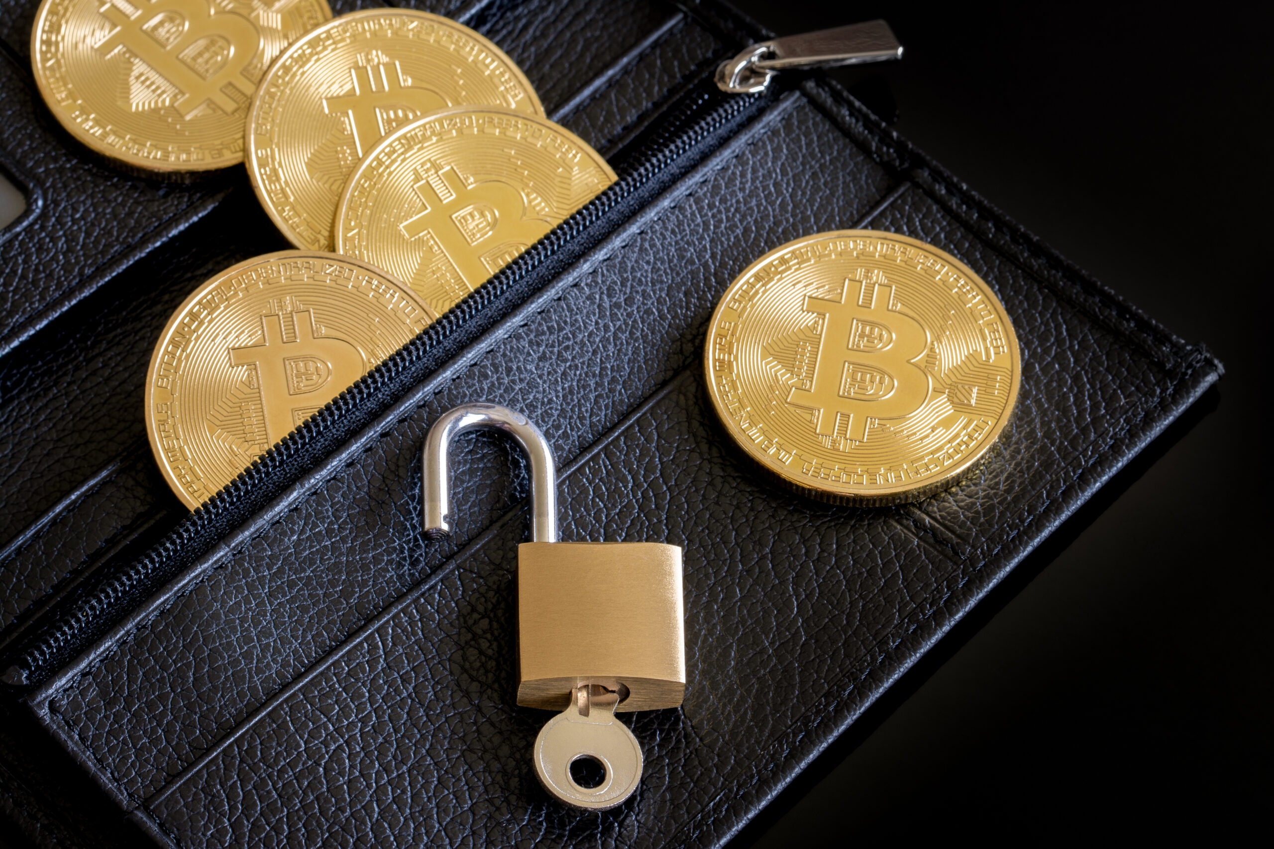 Bitcoins posés sur un porte-monnaie avec un cadenas ouvert