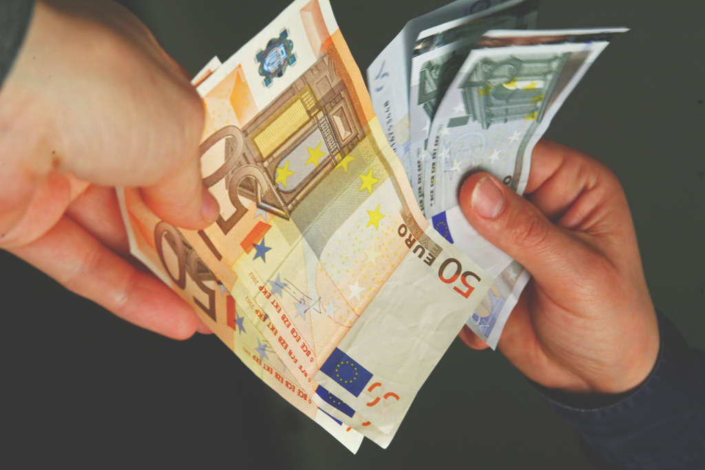 Two hands holding euro banknotes